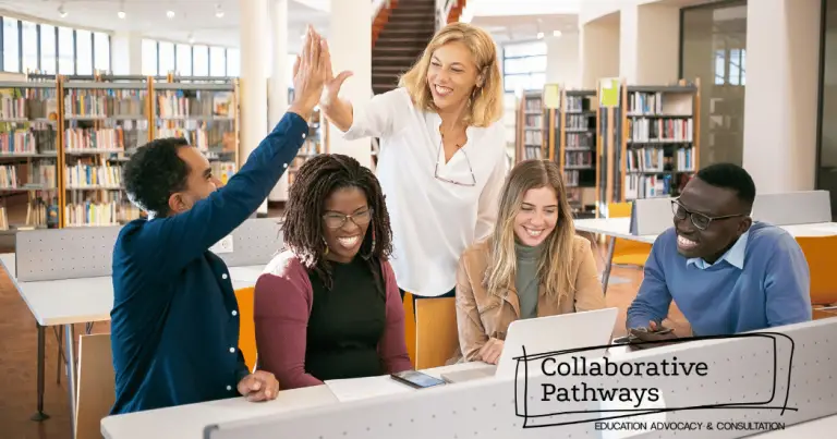 Image of teacher giving one of four students a high five in a library.