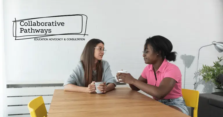 An image of two people talking to each other at a table with mugs in hand.